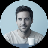 Circular portrait of a man, Chris Taylor, with a calm expression against a soft blue background, embodying a minimalist lifes
